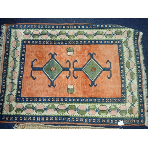 579 - A TURKISH RUG woven in blue and green with twin hooked lozenge medallions on a red ground within geo... 