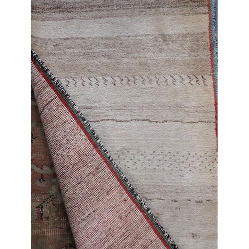 580 - A BERBER STYLE RUNNER the abrash mushroom field woven with scattered camel motifs and signed, within... 