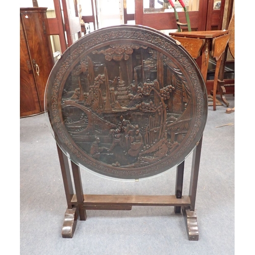 638 - A CARVED HARDWOOD CHINESE TABLE circular, with tip-up top