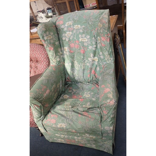 673 - AN EDWARDIAN WING ARMCHAIR upholstered with loose floral covers, on square tapered legs