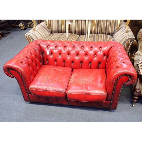 679 - A SMALL CHESTERFIELD SOFA, IN PATINATED RED LEATHER buttoned and studded, with bun feet 153cm wide