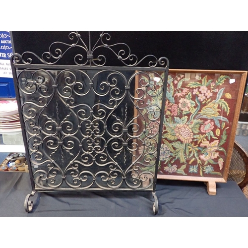 680 - A WROUGHT IRON FIRESCREEN 90 cms high, with an oak framed tapestry firescreen