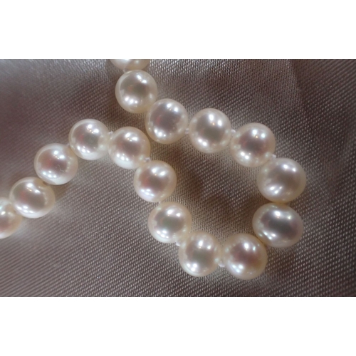 526 - A SINGLE STRAND PEARL NECKLACE, WITH 9CT CLASP with a pair of pearl earrings, each hung with a baroq... 