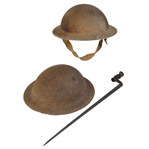 496 - TWO WWII BRITISH ARMY HELMETS with original lining and canvas chin straps; and one spike socket bayo... 