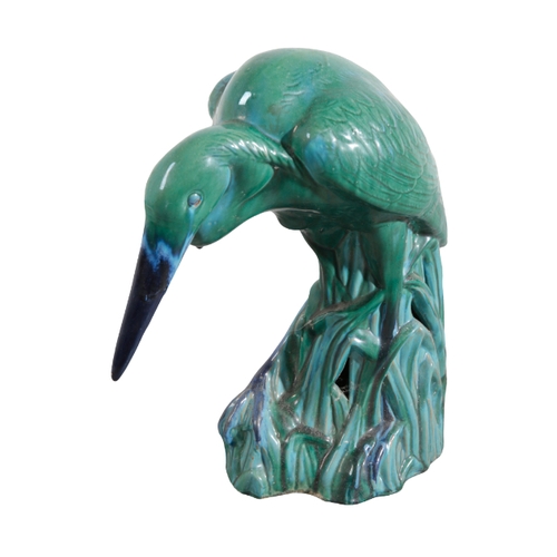 10 - A LARGE GREEN GLAZED CERAMIC HERON 20th century, standing in figured and pierced reeds, 66cm high, t... 