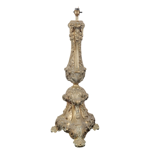 144 - TWO SIMILAR CONTINENTAL BRASS ALTAR LAMPS both of tripod form, decorated to the base with figural re... 