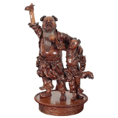 150 - A CHINESE CARVED WOOD LAMP BASE 20th century, in the form of a figural group, the electrical fitment... 