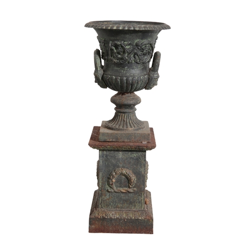 35 - A PAIR OF CAST IRON URNS each decorated with foliate banding, above turned pedestal bases, mounted o... 