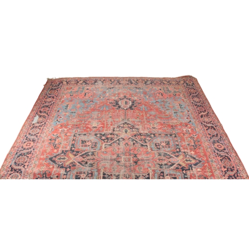 350 - A HERIZ CARPET early 20th century, the central geometric medallion on a red ground with all-over sty... 