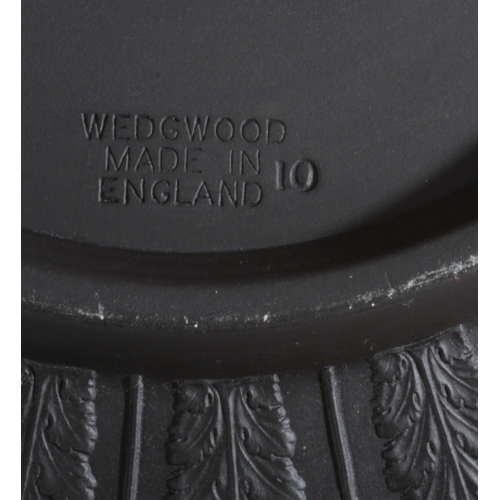 51 - A WEDGWOOD BLACK BASALT FRUIT BOWL in the dancing hours pattern, 11.5cm high x 25.5cm wide, together... 