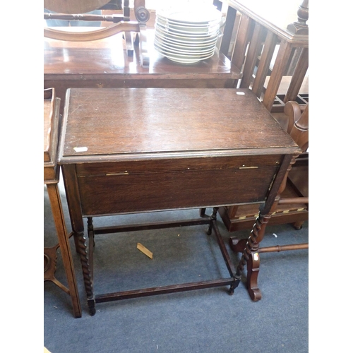 763 - A 1920S OAK WORK/WRITING TABLE on barley-twist legs, the top revealing a hinged writing surface and ... 