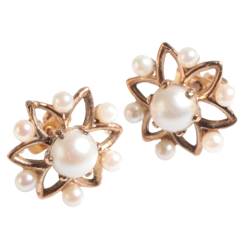18 - A PAIR OF 9CT GOLD AND PEARL EARRINGS of star design, the central cabochon pearl surrounded by six s... 