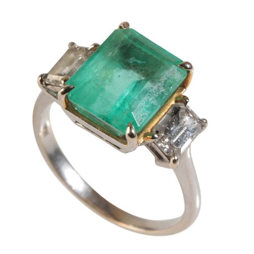 29 - AN EMERALD AND DIAMOND RING with step-cut diamond shoulders, the central emerald calculated weight a... 