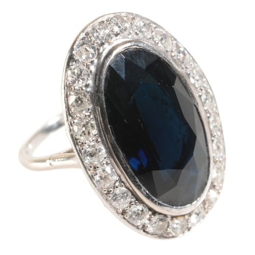 55 - A LARGE SAPPHIRE AND DIAMOND DRESS RING in a rub-over setting, on an unmarked shank, the sapphire me... 