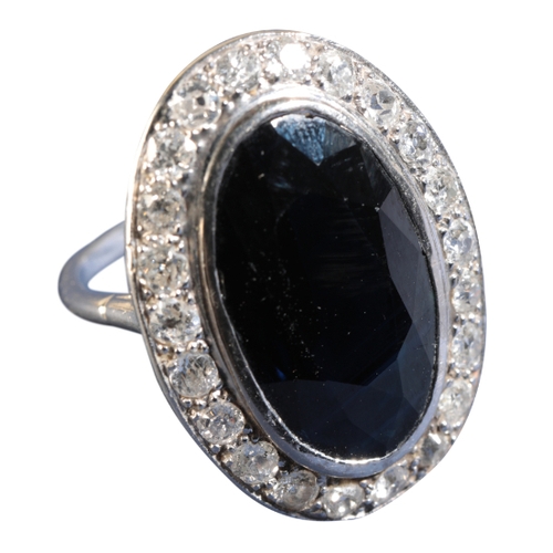 55 - A LARGE SAPPHIRE AND DIAMOND DRESS RING in a rub-over setting, on an unmarked shank, the sapphire me... 