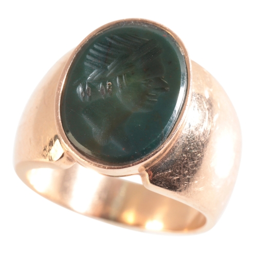 66 - A GOLD SIGNET RING (indistinct 750 mark), set with a Haematite Intaglio, size M½, (c.12.56g gross we... 