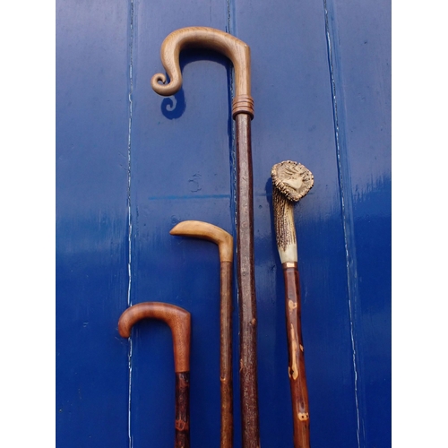 118 - FOUR WALKING STICKS, INCLUDING A CROOK one with a carved stag's antler head, others with wooden hand... 