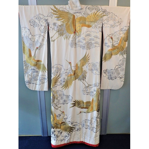 345 - A TRADITIONAL JAPANESE KIMONO, WORKED WITH CRANES AMONGST CLOUDS AND FLOWERS in silver and gold-colo... 