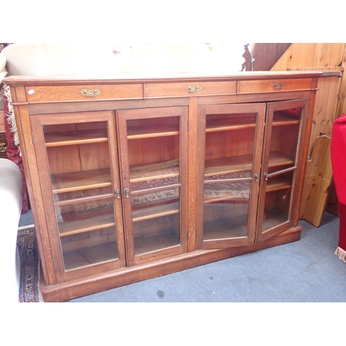 679 - A VICTORIAN OAK GLAZED BOOKCASE four doors with drawers over 121cm high, 184cm wide