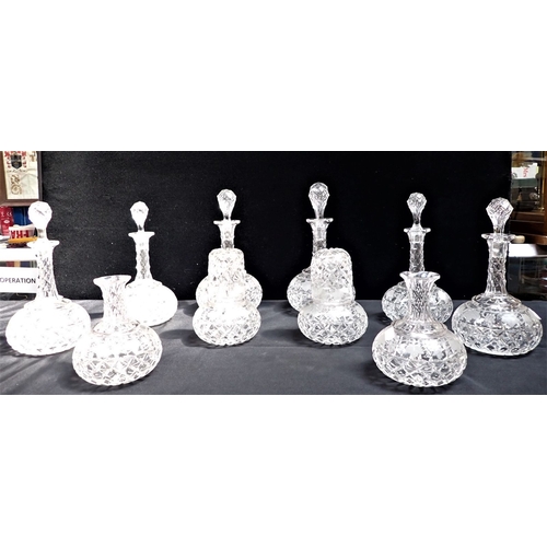 238 - A COLLECTION OF SIMILAR CUT AND VINE ENGRAVED DECANTERS and carafes (some odd or missing stoppers, c... 