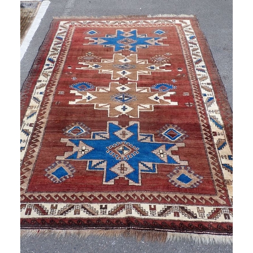 533 - A TRIBAL PATTERNED RUG in browns and blue 160 x 230cm plus fringes
