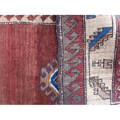 533 - A TRIBAL PATTERNED RUG in browns and blue 160 x 230cm plus fringes