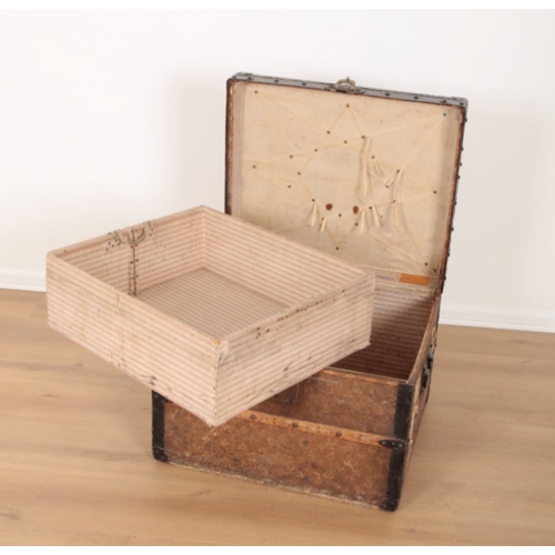 17 - A VINTAGE TRAVEL TRUNK decorated in Louis Vuitton style, the hinged lid opening to an interior fitte... 