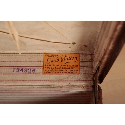 17 - A VINTAGE TRAVEL TRUNK decorated in Louis Vuitton style, the hinged lid opening to an interior fitte... 