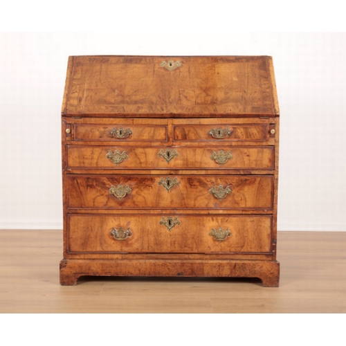 389 - AN EARLY GEORGE III FIGURED WALNUT BUREAU the crossbanded slope enclosing fitted interior, two short... 