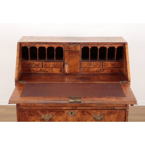 389 - AN EARLY GEORGE III FIGURED WALNUT BUREAU the crossbanded slope enclosing fitted interior, two short... 