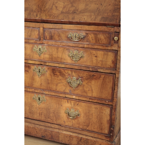 389 - AN EARLY GEORGE III FIGURED WALNUT BUREAU the crossbanded slope enclosing fitted interior, two short... 