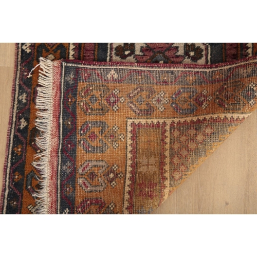 65 - A TURKISH RUNNER 20th century, the brick red ground with repeating medallions, within contrasting bo... 