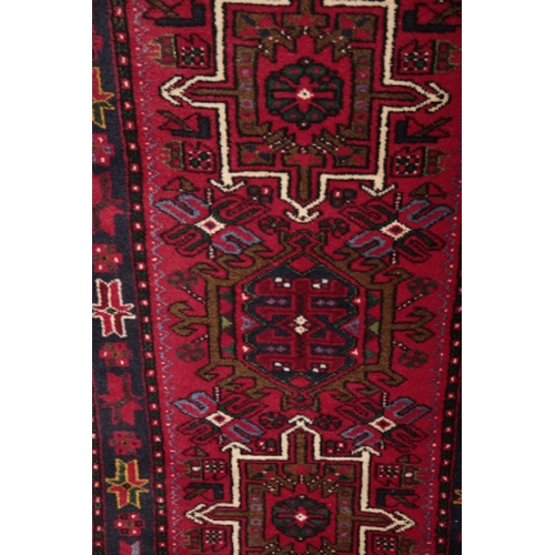 81 - A MESHAD RUNNER 20th century, the red ground decorated with stylised floral medallions, 428cm x 79cm