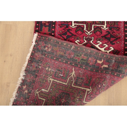 81 - A MESHAD RUNNER 20th century, the red ground decorated with stylised floral medallions, 428cm x 79cm