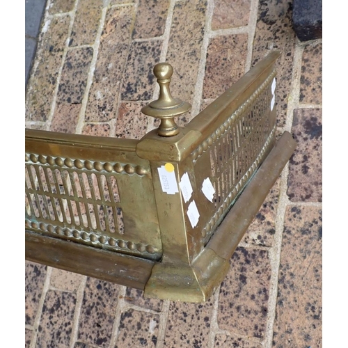 175 - A PIERCED BRASS FENDER, WITH  FINIALS 126cm wide