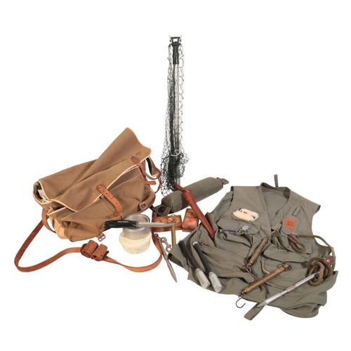 122 - A CANVAS FISHING BAG containing fishing priests, brass scales, a hunting knife, a Hardy fishing vest... 