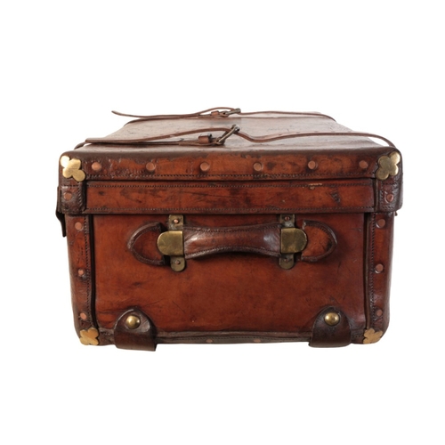 257 - A VICTORIAN LEATHER AND BRASS-BOUND TRAVELLING TRUNK with leather carrying handles and straps, inscr... 