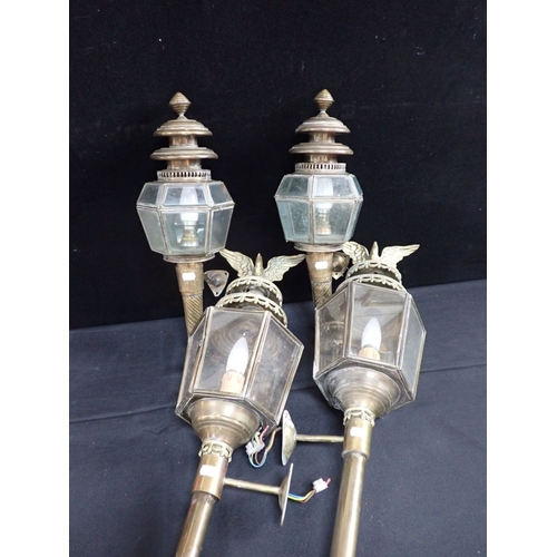 309 - TWO PAIRS OF WALL-MOUNTED BRASS LANTERNS one with eagle surmount, electrified, 68cm and 53cm high