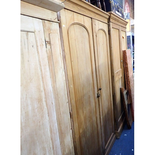 917 - HEAL & SON: A VICTORIAN STRIPPED PINE WARDROBE with arched panel doors and fitted interior 126cm wid... 