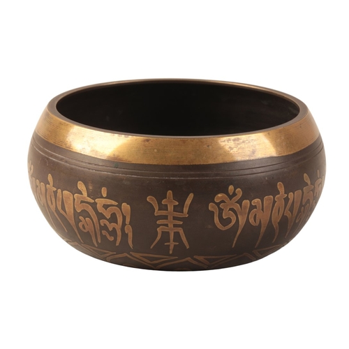 522 - AN INDIAN BRONZE BOWL

the exterior inset with Hindu calligraphy, the interior with cast roundel dep... 