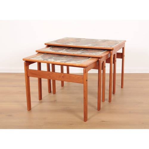 560 - A NEST OF THREE TEAK TABLES

mid 20th century, each with hand painted tile inset tops, the largest 4... 