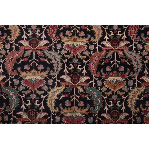 593 - AN ANTIQUE PERSIAN TABRIZ CARPET

woven in colours with endless leaf repeat on a dark blue ground, s... 