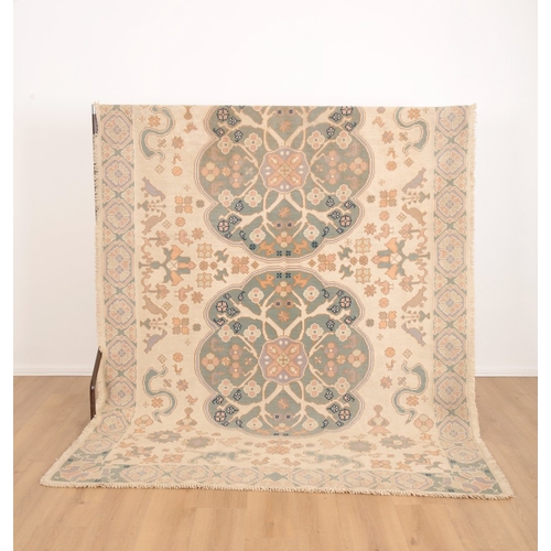 648 - A 'PORTUGUESE' FLAT STITCH RUG

20th century, the light ground with two contrasting floral medallion... 