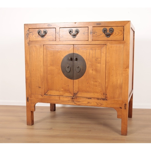 849 - A CHINESE ELM SIDE CABINET

20th century, with three short drawers over a cupboard, opening to a she... 