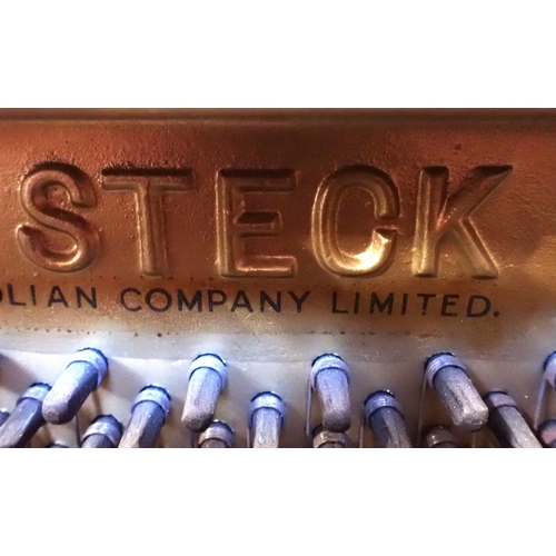 124 - STECK: AN UPRIGHT PIANO IN AN ART DECO WALNUT AND CROSSBANDED CASE with stepped sides and concave fo... 