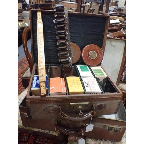 184 - A CARTRIDGE CASE HOLDER BELT, LEATHER COVERED TAPE MEASURES and another measure, in an old case