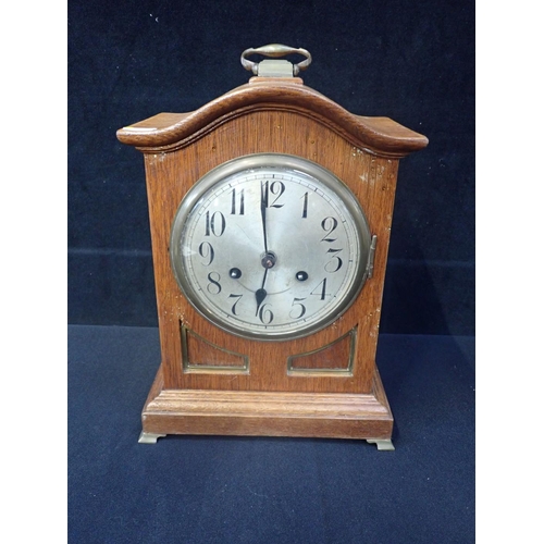 239 - AN EDWARDIAN OAK-CASED MANTEL CLOCK with Junghans movement and silvered dial (a/f)