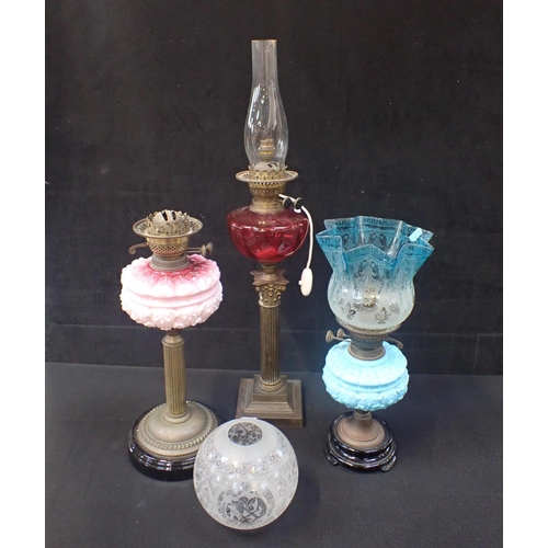 247 - THREE VICTORIAN OIL LAMPS one with cranberry glass reservoir (two converted to electricity)