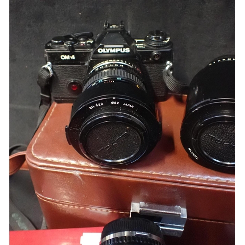 268 - AN OLYMPUS OM-4 35MM SLR CAMERA with two Tonkina lenses and a Sigma 28mm lens, contained in brown le... 