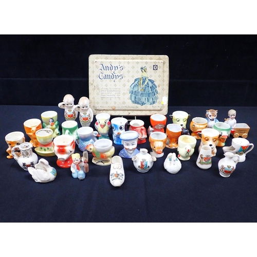 76 - A COLLECTION OF EARLY 20TH CENTURY NOVELTY EGGCUPS (some with damage) and similar items, including c... 